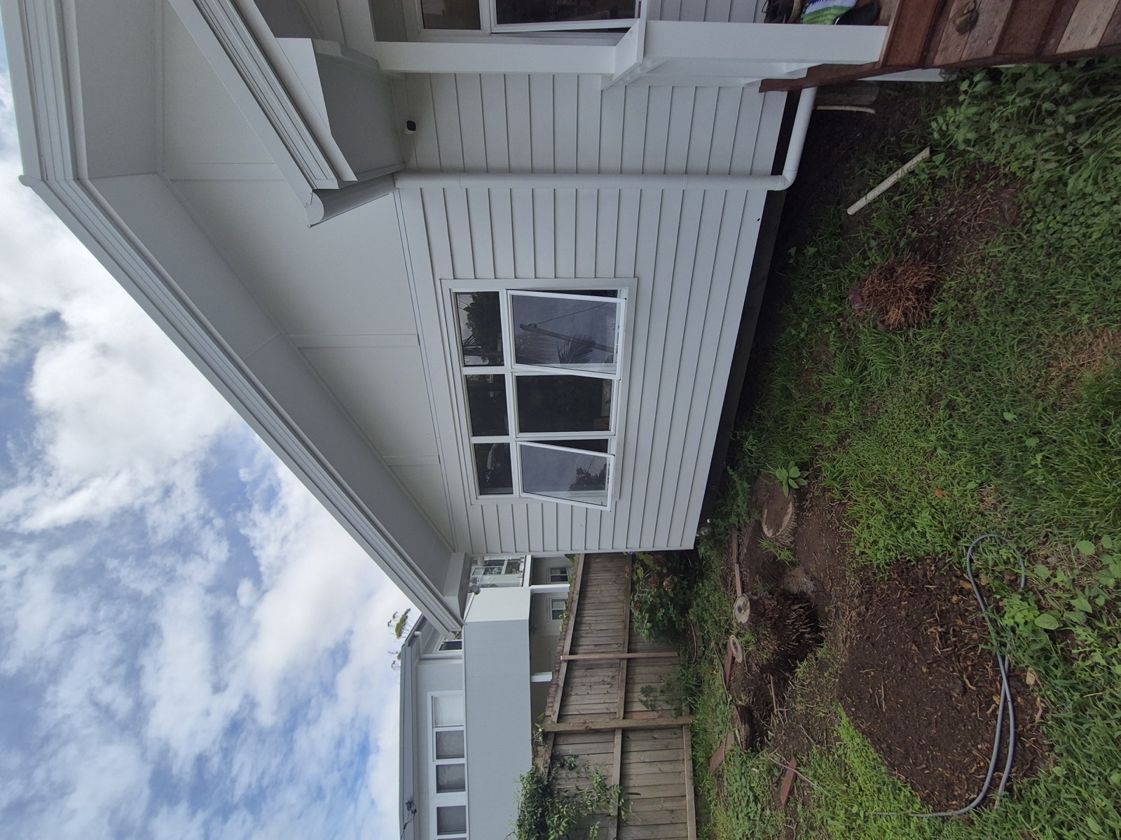 Crisp white weatherboard exterior repaint against blue sky