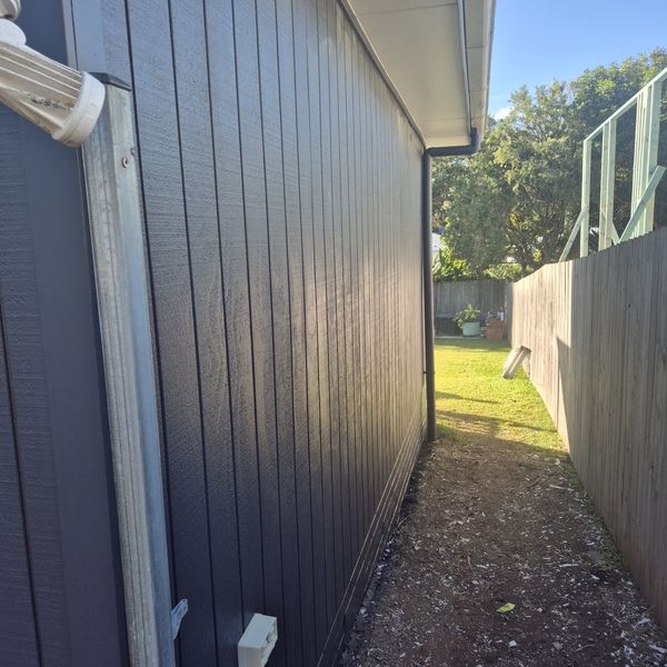 Dark exterior cladding and new deck finished by Bodes Brushes
