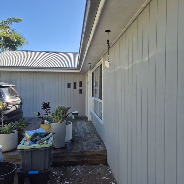 Weatherboard exterior repaint under a blue sky
